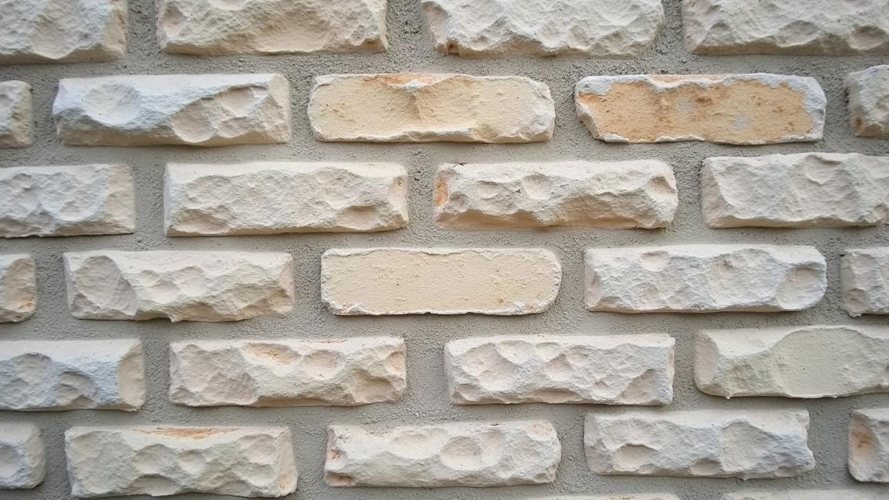 Mur en pierre calcaire à l'appareillage irrégulier, joints creusés visibles entre les blocs